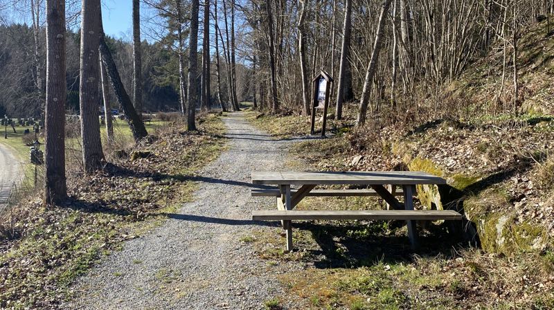 Klokketårnet ved Nesodden kirke med to benker. Bildet av Bjørn Egil Kihlstrøm.
