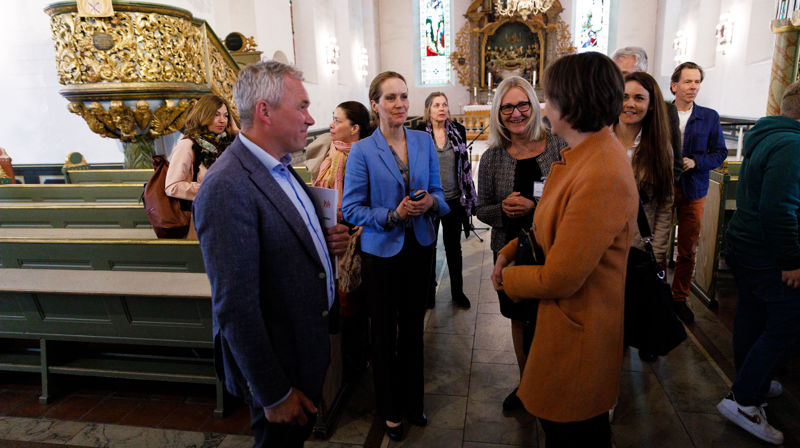 Bygg- og eiendomssjef Andre E. Selli i samtale med statsråd Kjersti Toppe (orange) og riksantikvar Hanna Geiran (blå). Foto: Even Kleppa