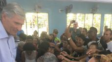 Bildet viser tidligere generalsekretær i bibelselskapet Stein Mydske som deler ut barnebibler på en stor gudstjeneste. Biblene ble nesten revet ut av hendene hans!