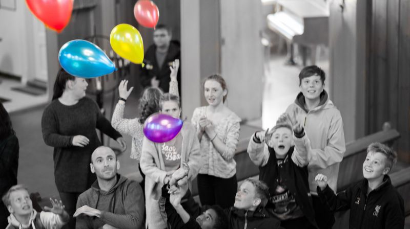 Tweensklubben tar imot fargerike ballonger som slippes fra galleriet i kirken
