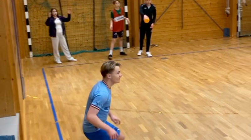 Ungdommer spiller ballspill inne i en gymsal