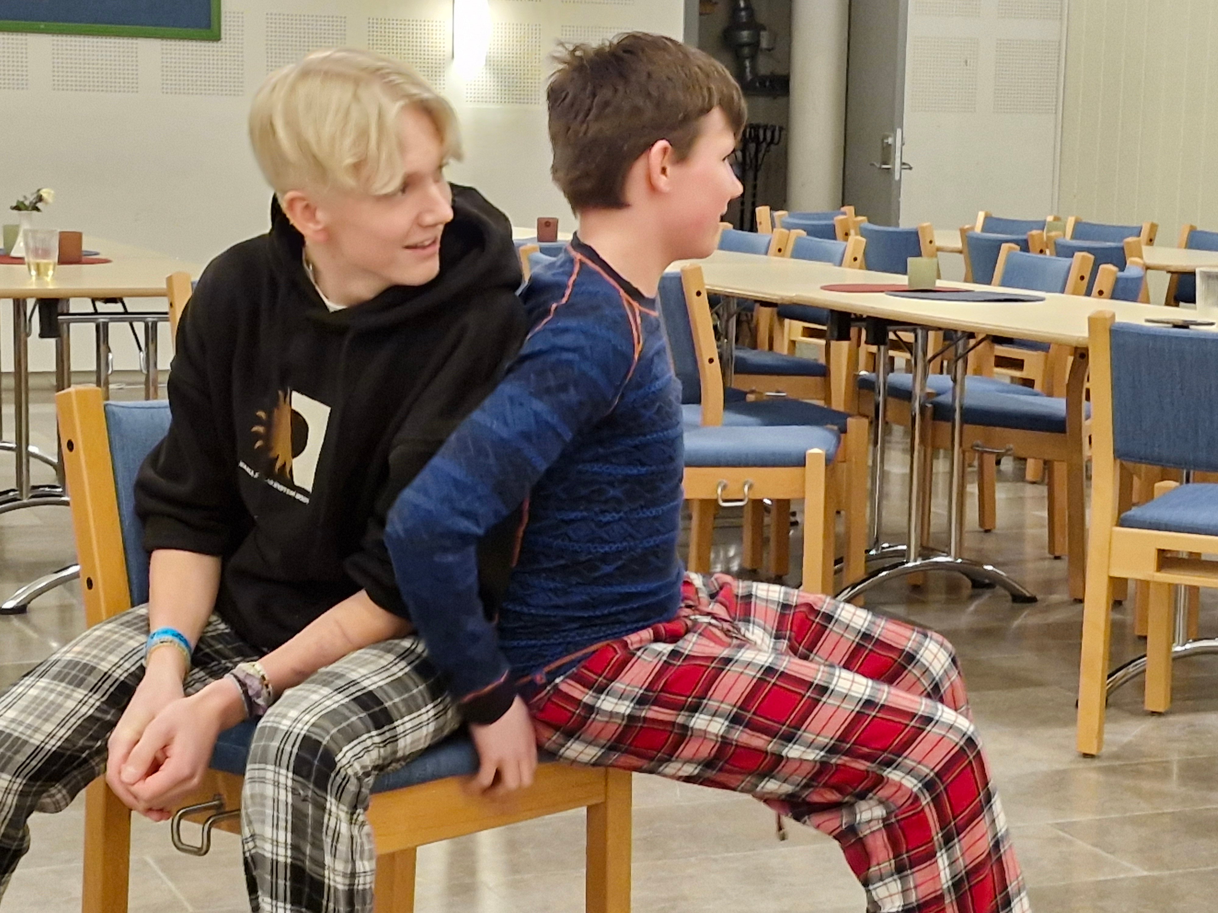 To ungdomsgutar sit på den siste stolen i stolleiken, den eine sitt meir på stolen en den andre