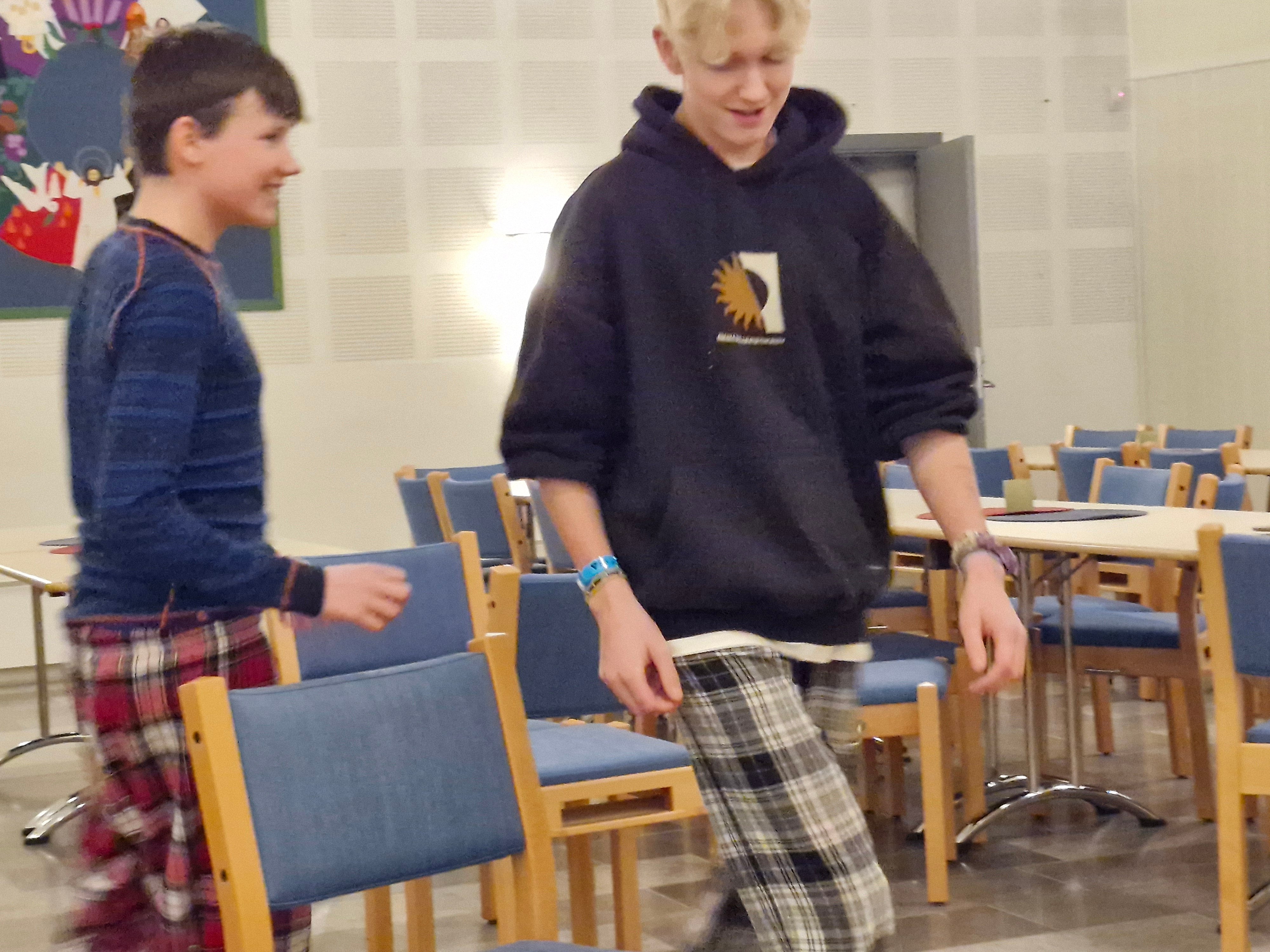 To ungdomsgutar går rundt den siste stolen i stolleiken
