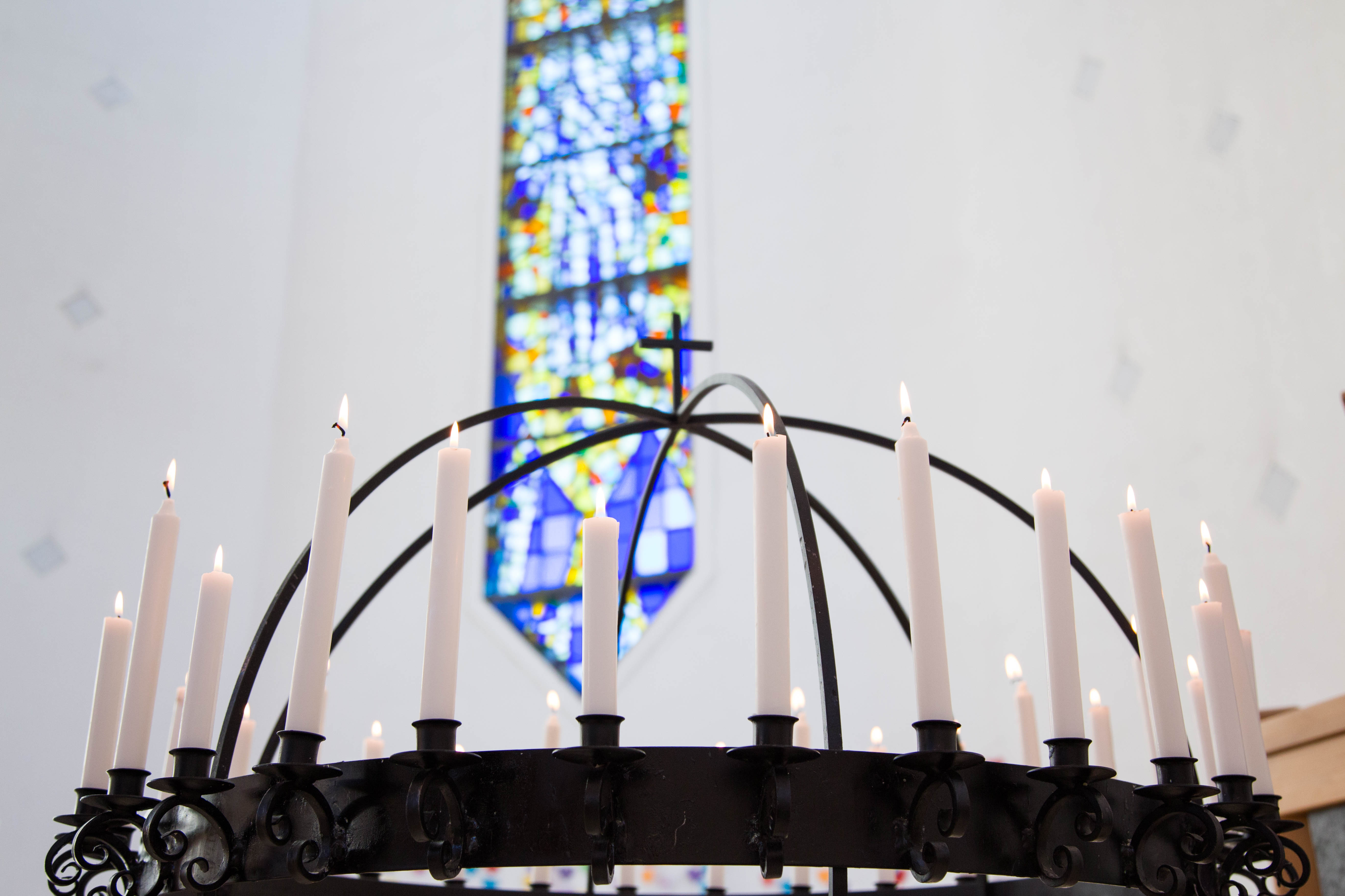 Lysgloben i SUnd kyrkje med tente lys, i bakgrunnen kan ein sjå glassmaleriet
