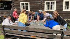 Heidal kirke: Hvilke kort skal jeg velge? Aktiv gjeng utendørs på steinbordet ved Heidal kirke, og værgudene var absolutt på vår side. Foto: Astrid M. Sæther.