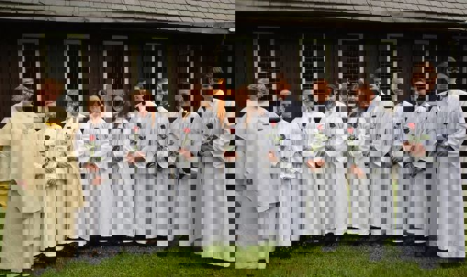 Konfirmanter i konfirmantkapper med prest