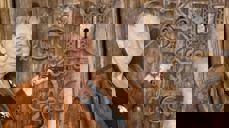 Mangeårig guide Marianne foran stavkirkedøra i Reinli