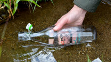 Flasken fylles med vann fra Sunnivaskilden.