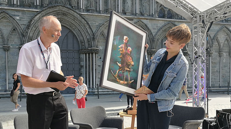 Kirkeakademienes styreleder Kjell Y. Riise delte tirsdag ut prisen til Ella Marie Hætta Isaksen. (Foto: Kirkerådet)