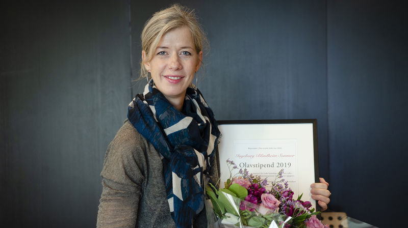 Synstolkning: Foto av Ingeborg Blindheim Sommer med sitt Olavstipenddiplom. Foto: Hege Flo Øfstaas