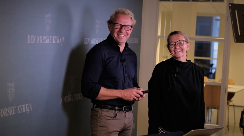 Framfor ein reklamevegg med kyrkja sin logo: Leiar i hovudutvalet Morten Müller-Nilssen og prosjektdirektør Inger Kari Stensrud, i prosjektet knytt til ny kyrkjeleg organisering.